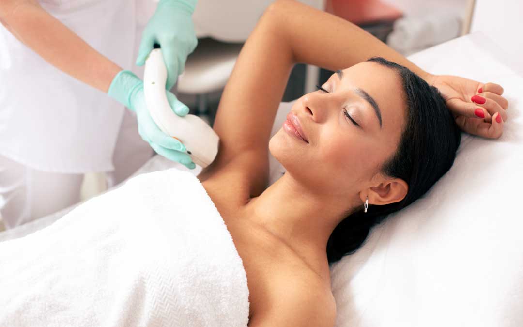Woman getting laser hair removal treatment under her arm